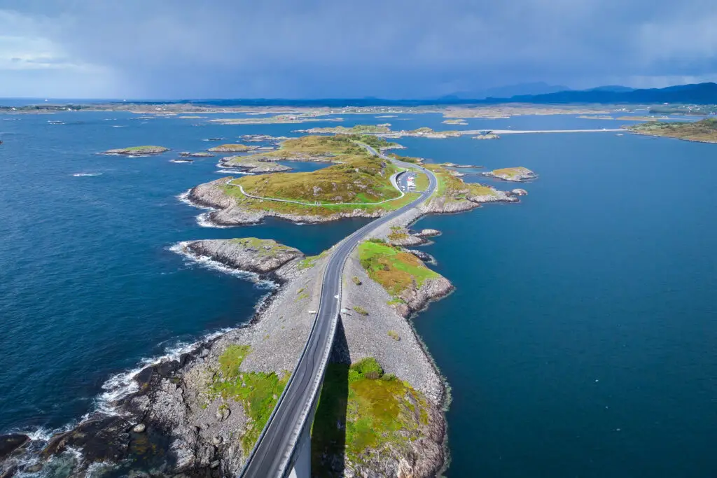 Aerial view of the scenic Atlantic Ocean Road (Atlanterhavsveien) winding through rugged coastal landscapes in Norway, a stunning symbol of scenic Norwegian tourism and engineering.