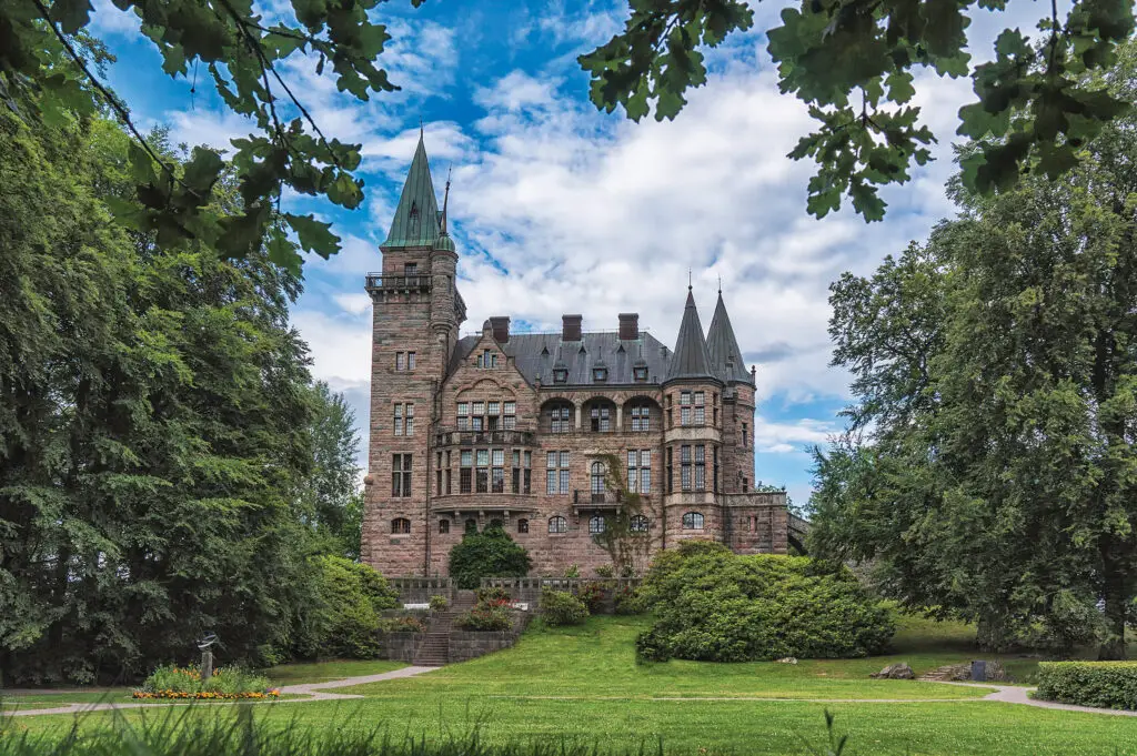 Teleborg Castle in Sweden surrounded by lush greenery under a clear blue sky, a popular destination for tourists exploring Scandinavian heritage.