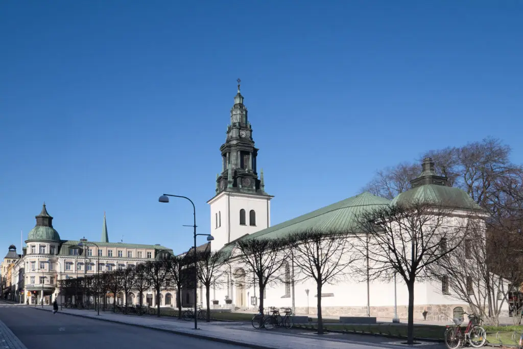 Church of Saint Lars in Linkoping, Sweden, showing the historic architecture and serene surroundings under a bright blue sky.