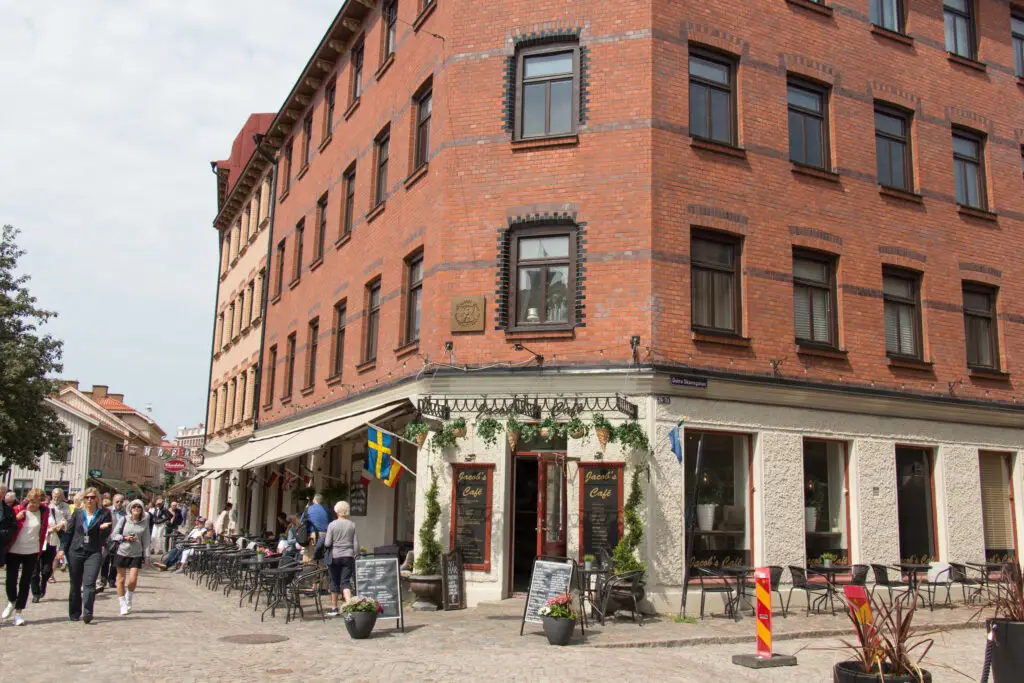 Charming street view in Haga district, Gothenburg, featuring traditional architecture and local café with pedestrians enjoying the scenery