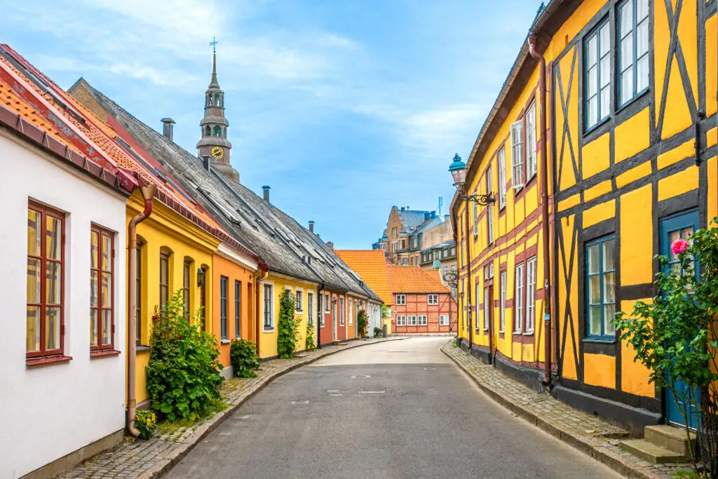Colorful traditional Swedish houses lining a cobblestone street in Ystad, Skåne, showcasing Scandinavian architecture and cultural heritage.