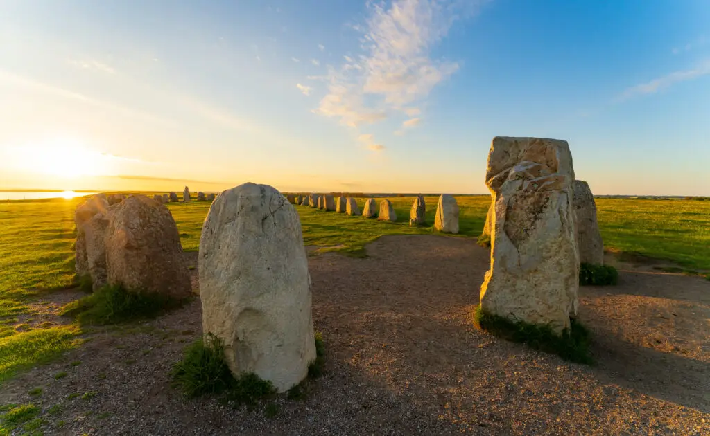 Summer sunset over Ale Stones (Ales stenar), a megalithic monument with 59 large boulders in Kåseberga, Sweden, reflecting Scandinavian heritage and ancient history.