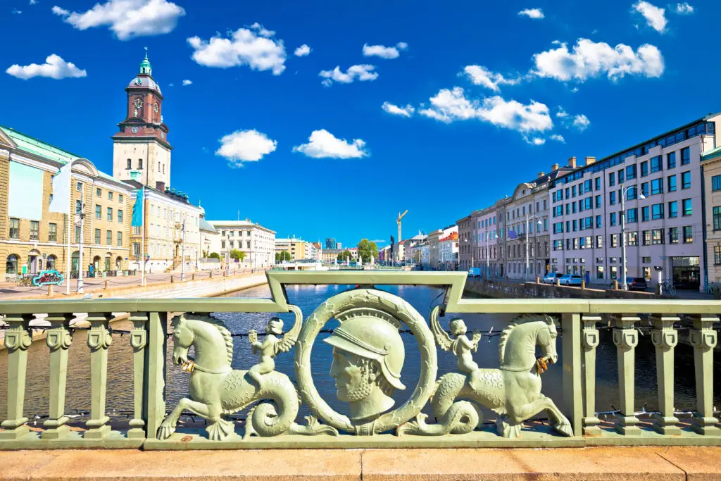 View of historical architecture and decorative bridge railing in Gothenburg, Sweden, featuring ornate sculptures and the city's vibrant canal.